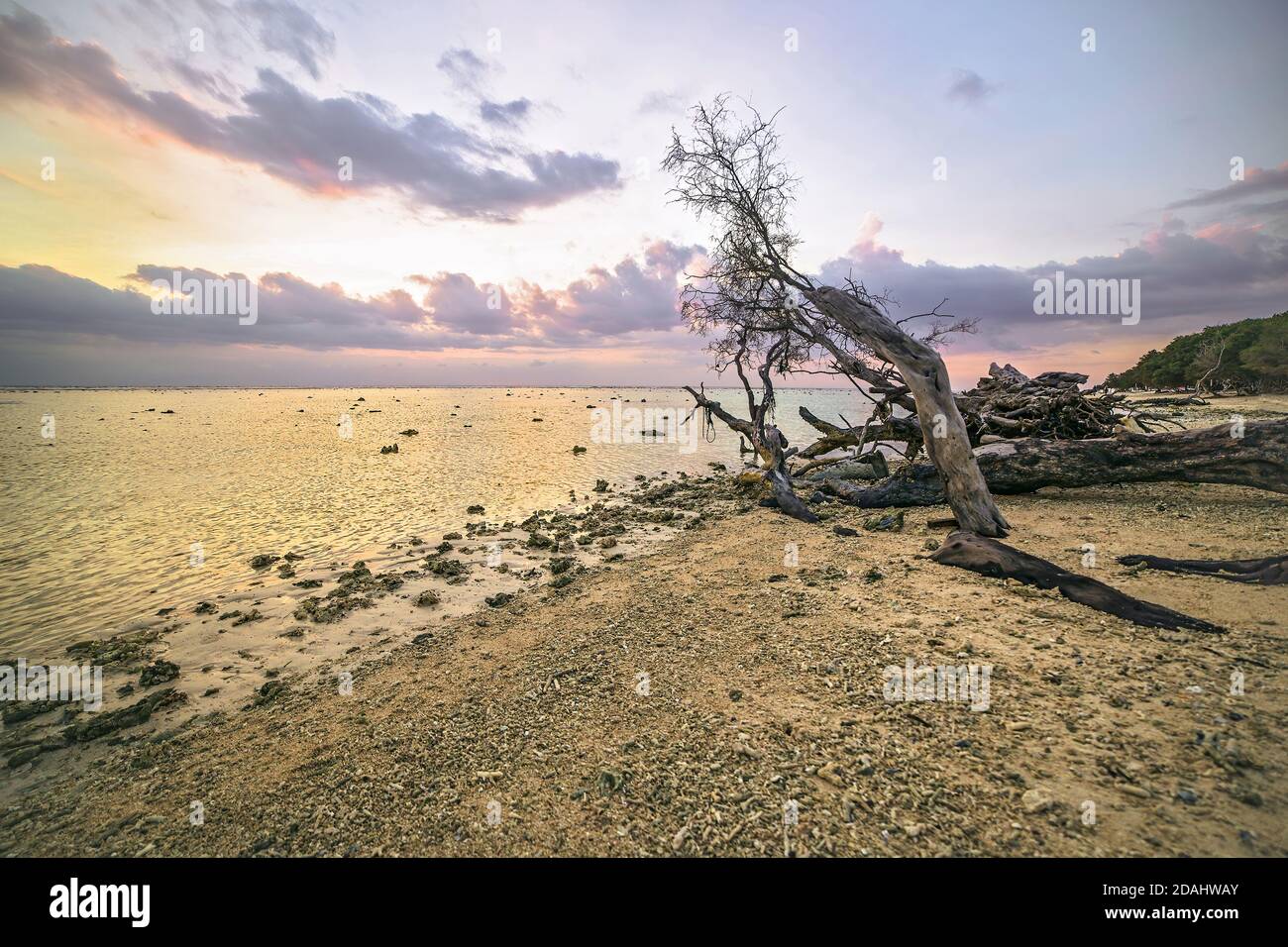 Malerischer Blick auf einen Korallenstrand in Gili T. bei einem magischen Sonnenuntergang mit Wolken, Gili Trawangan, Bali Indonesien Stockfoto