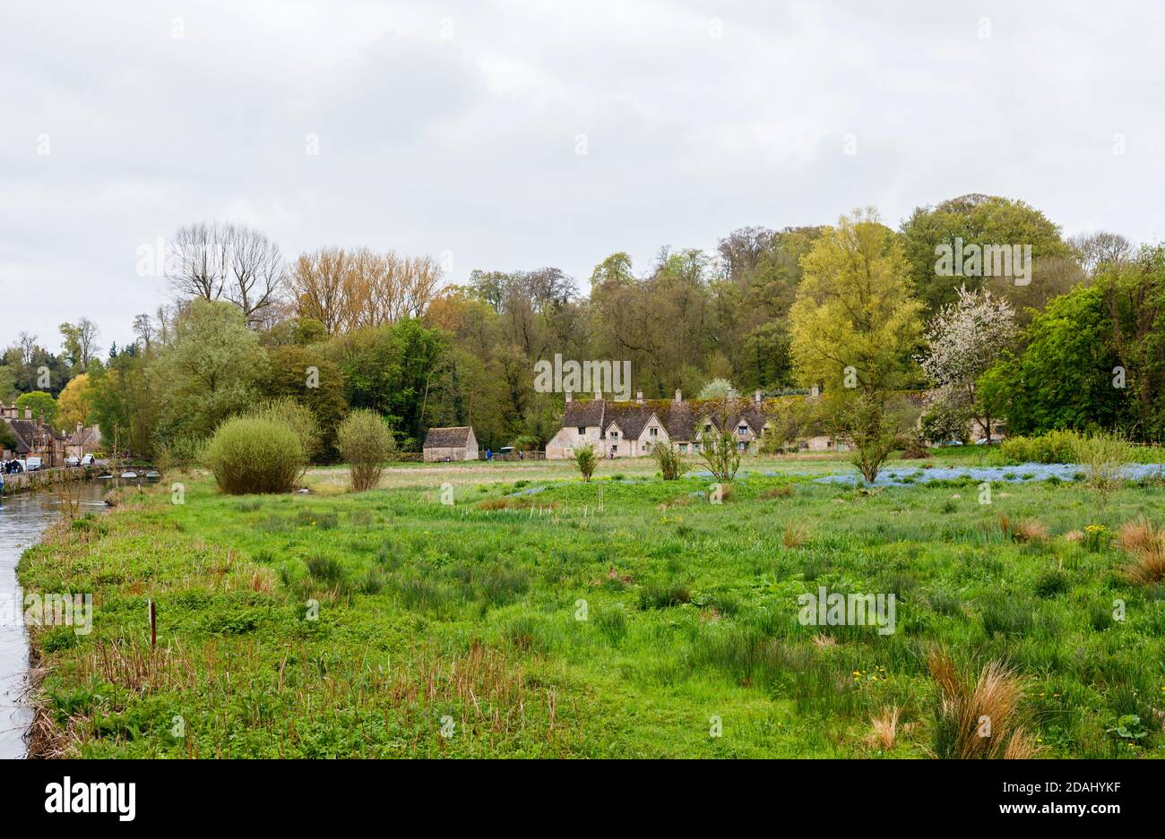 Blick über den Fluss Coln der traditionellen Cotswold Steinhütten in Arlington Row in Bibury, einem ziemlich unberührten Dorf in Gloucestershire Cotswolds Stockfoto