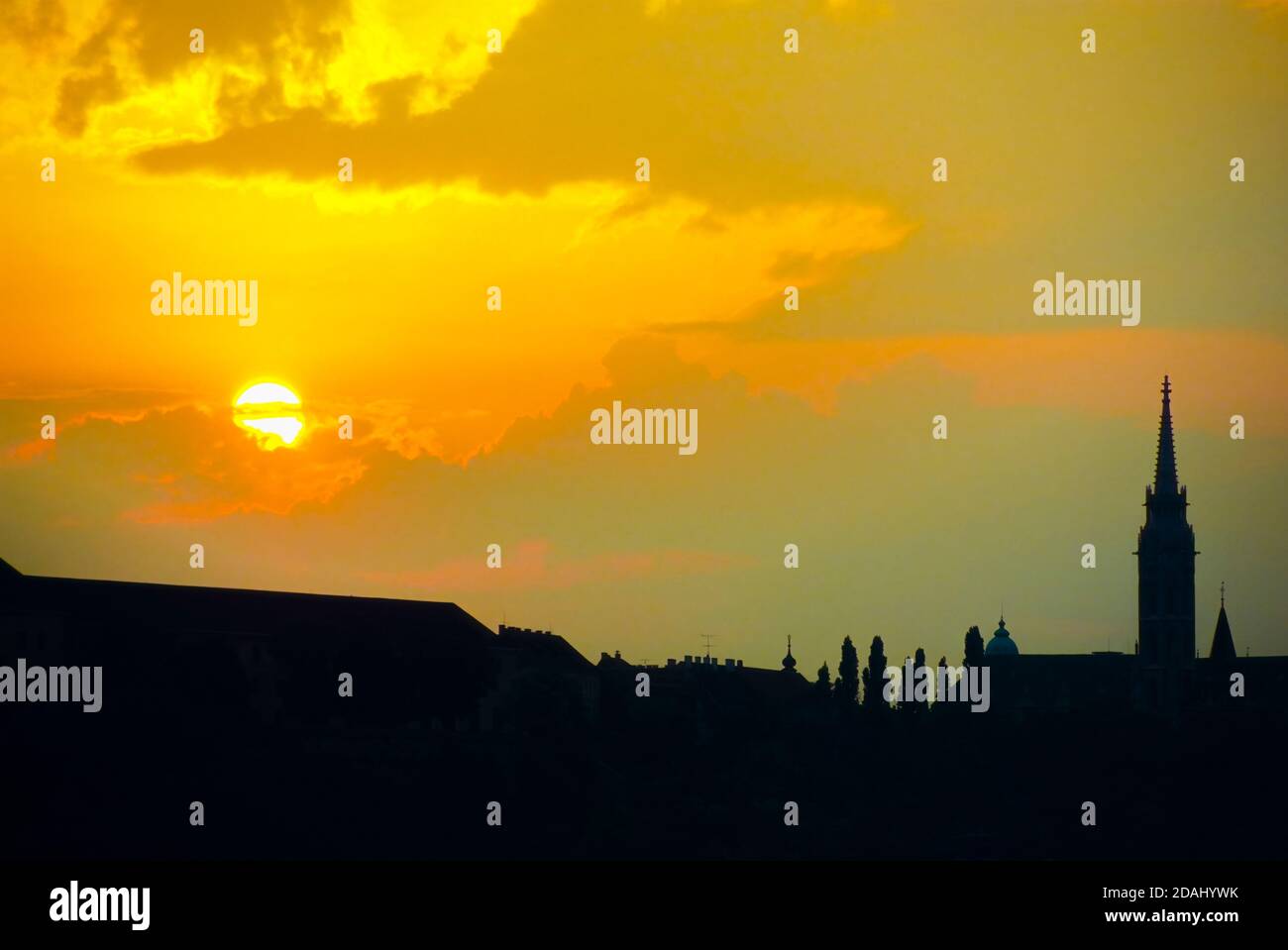 Klassischer leuchtender orangefarbener Sonnenuntergang über der Donau in Budapest, der Hauptstadt Ungarns mit Blick auf die Skyline von Pest und den Kirchturm von Matyas Stockfoto