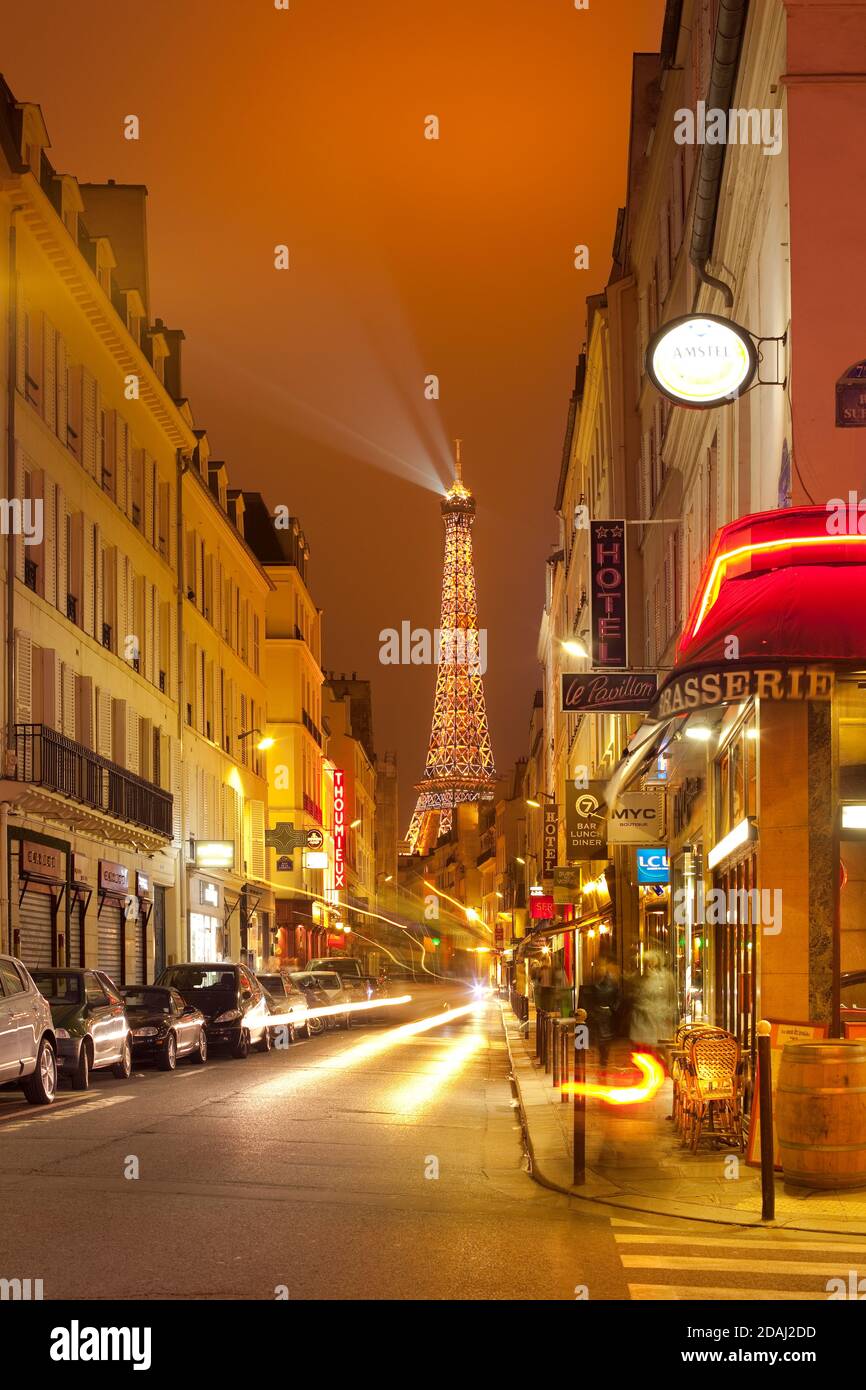 Paris, Frankreich - Nachtleben in Pariser Cafés mit dem Eiffelturm im Hintergrund. Stockfoto