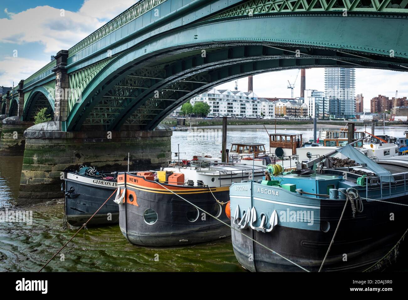 Lastkähne in Hausboote umgewandelt, sitzen auf der Themse Schlamm bei Ebbe unter Battersea Railway Bridge (ursprünglich genannt Cremorne Bridge Stockfoto