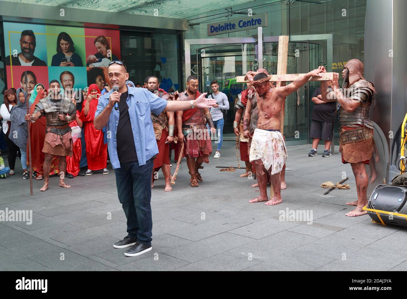 Eine Straßennachstellung der Kreuzigung Jesu durch Mitglieder einer polynesischen Kirche in Auckland, Neuseeland. Ein Prediger spricht die Menge an Stockfoto