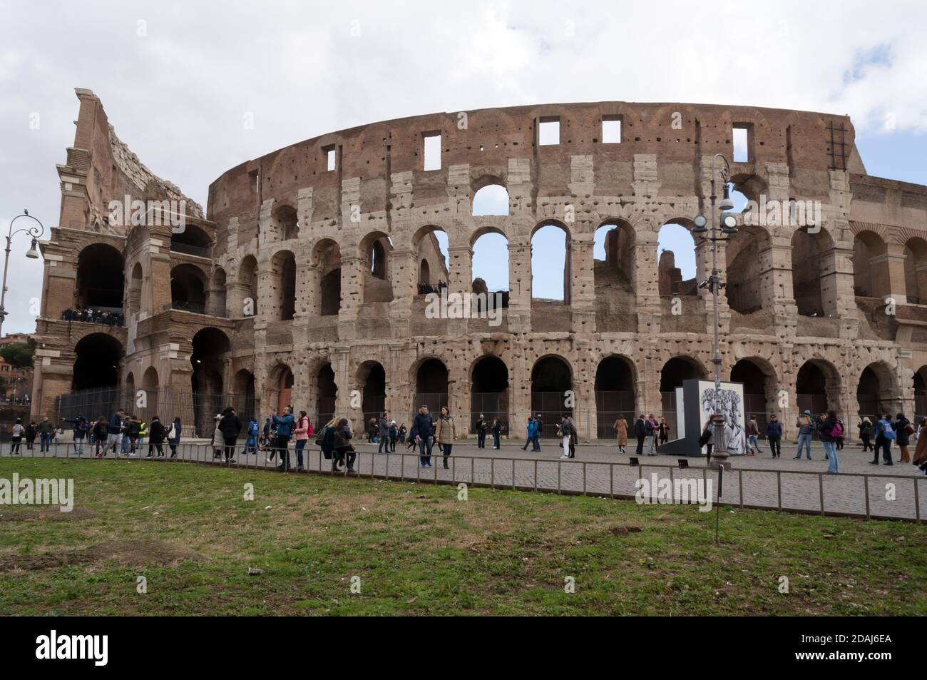 Touristen sind in der Nähe der Wand des Amphitheaters Kolosseum (Baujahre 72-80), ein architektonisches Denkmal des antiken Rom. Stockfoto