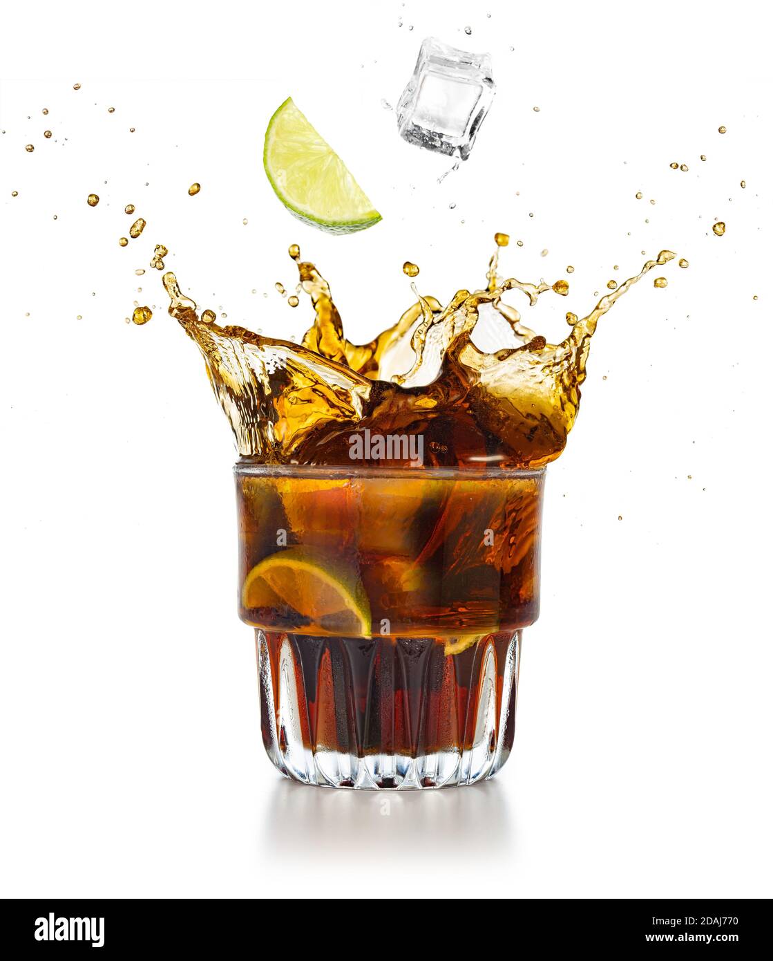 Limettenkeil und Eiswürfel, die in eine spritzende Cola fallen Trinken Stockfoto