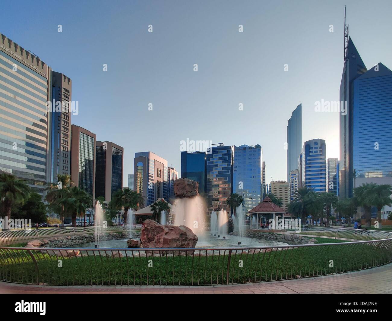 Berühmter Stadtpark von Abu Dhabi in der Innenstadt - wunderschön modern parkszene bei Sonnenuntergang umgeben von Wolkenkratzern - stressfrei Anzeigen Stockfoto