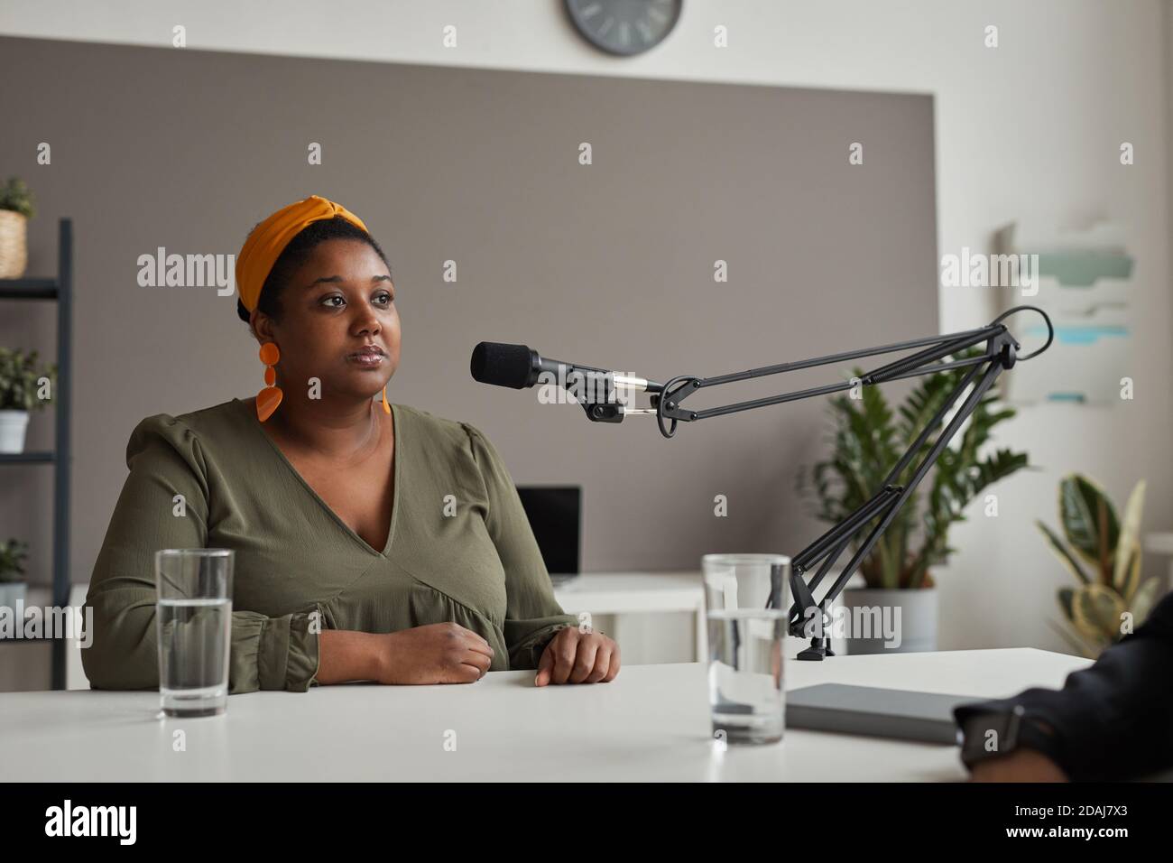 Afrikanisch übergewichtige Frau sitzt am Tisch und spricht weiter Mikrofon gibt ein Interview im Radio Stockfoto