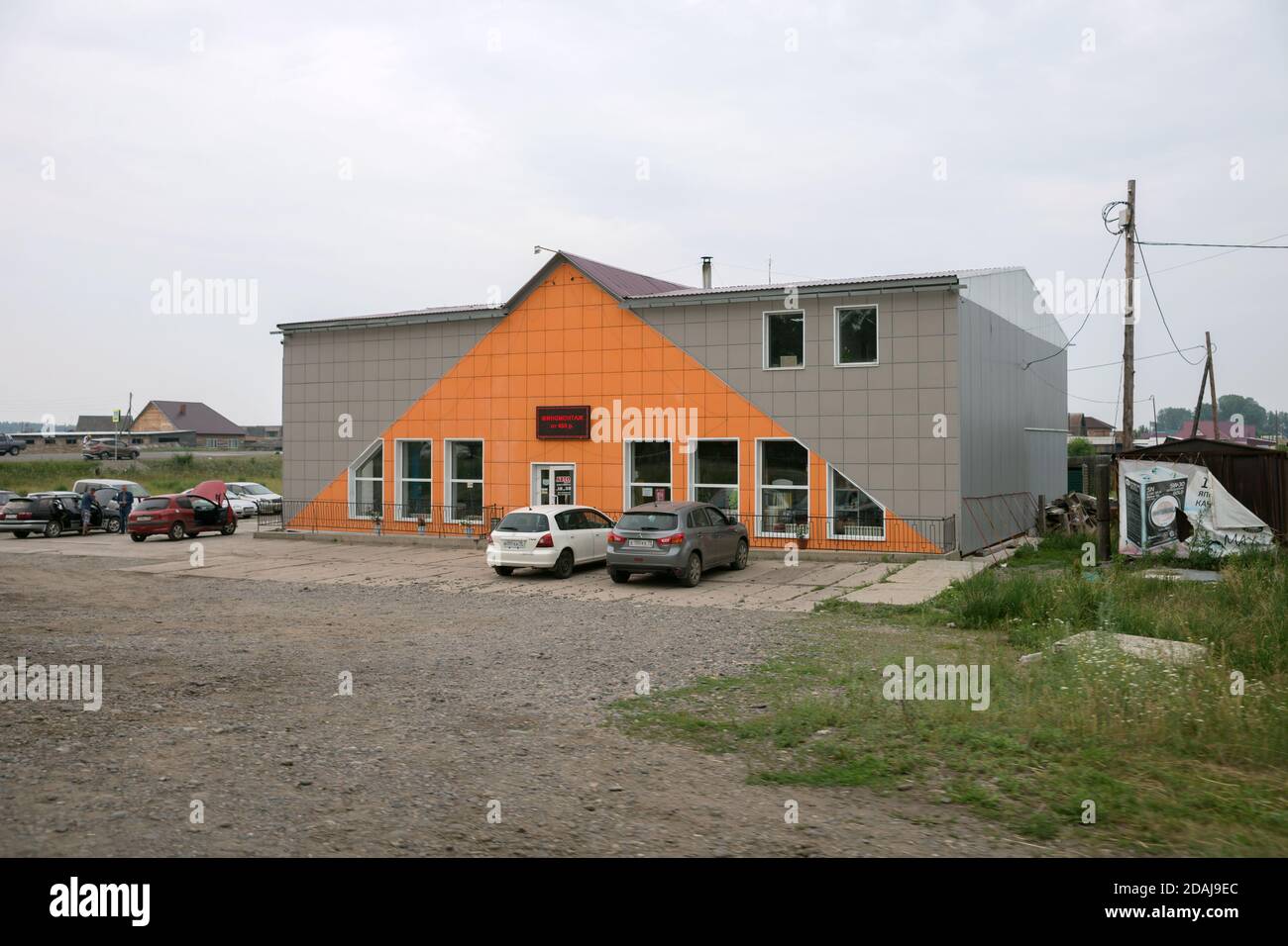 Modernes Gebäude des Autodienstes mit Autos davor, im Dorf Schuschenskoje in der Region Krasnojarsk. Russland. Stockfoto