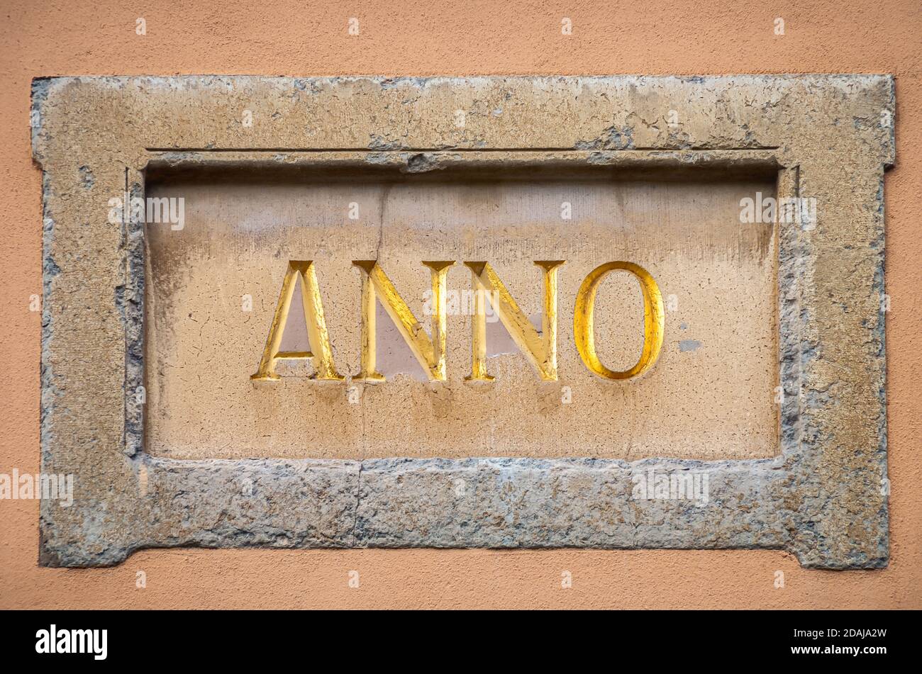 Dekorativer Rahmen oder Kartusche mit der lateinischen Aufschrift ANNO für 'im Jahr' auf einer Hausfassade. Stockfoto