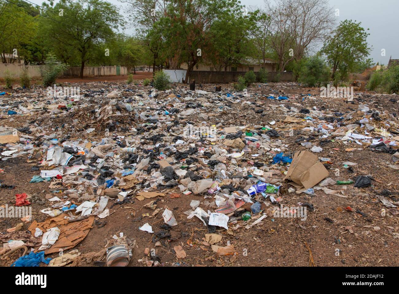 Selingue, Mali, 26. April 2015; ohne ordnungsgemäße Abfallentsorgung in der Stadt stapeln sich Plastik und andere Abfälle auf ungenutzten Grundstücken. Stockfoto