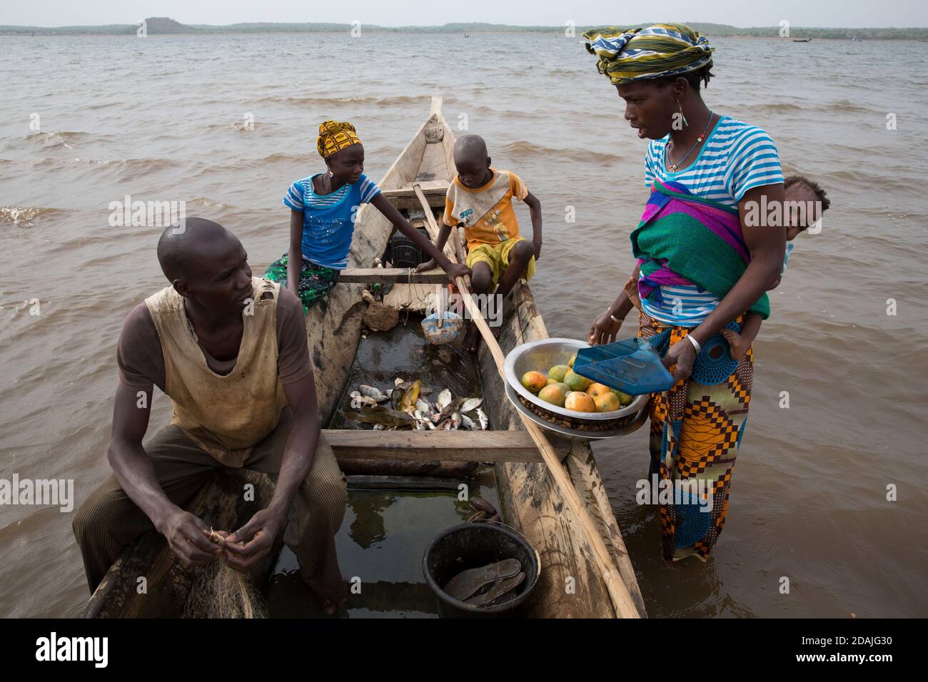 Selingue, Mali, 27. April 2015; Fisherman Mama Kanta, 32, Mit seinem Bruder Soumala 9 und seiner Schwester Fatouma, 14. Sie tauschen mit Djenebou Sidibe gegen einen Beutel Erdnüsse, die ihre Familie ernähren soll. Stockfoto