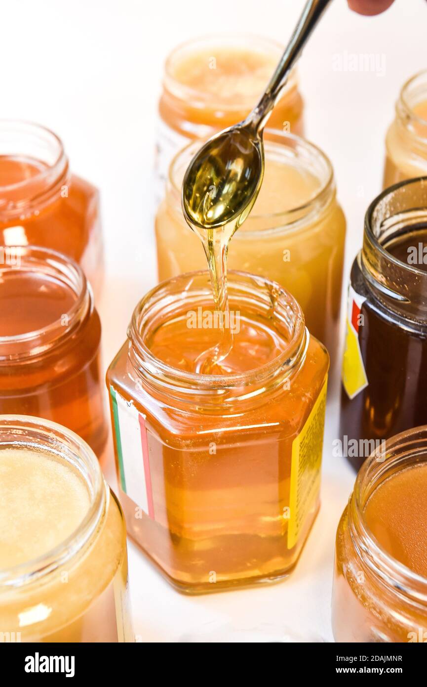 Honiggläser mit Teelöffel. Stockfoto