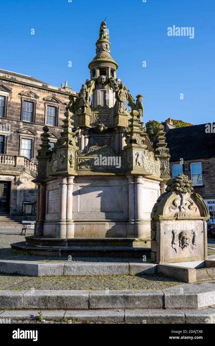 Brunnen mit Kreuzbrunnen vor den Linlithgow Burgh Halls - The Cross, Linlithgow, West Lothian, Schottland, Großbritannien Stockfoto