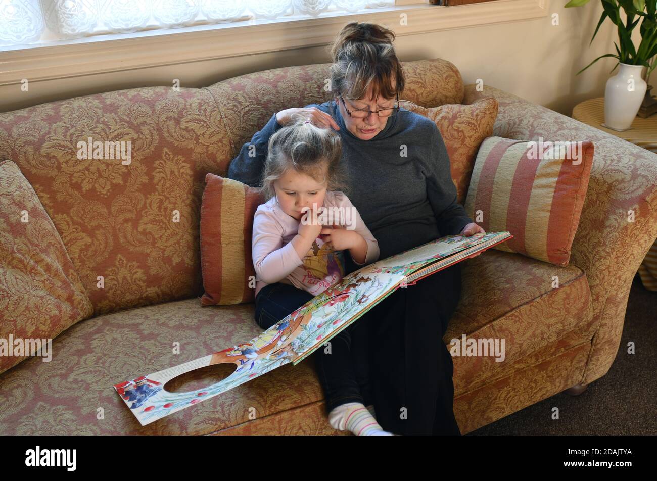 Großmutter liest vor Enkelkind Großbritannien Stockfoto
