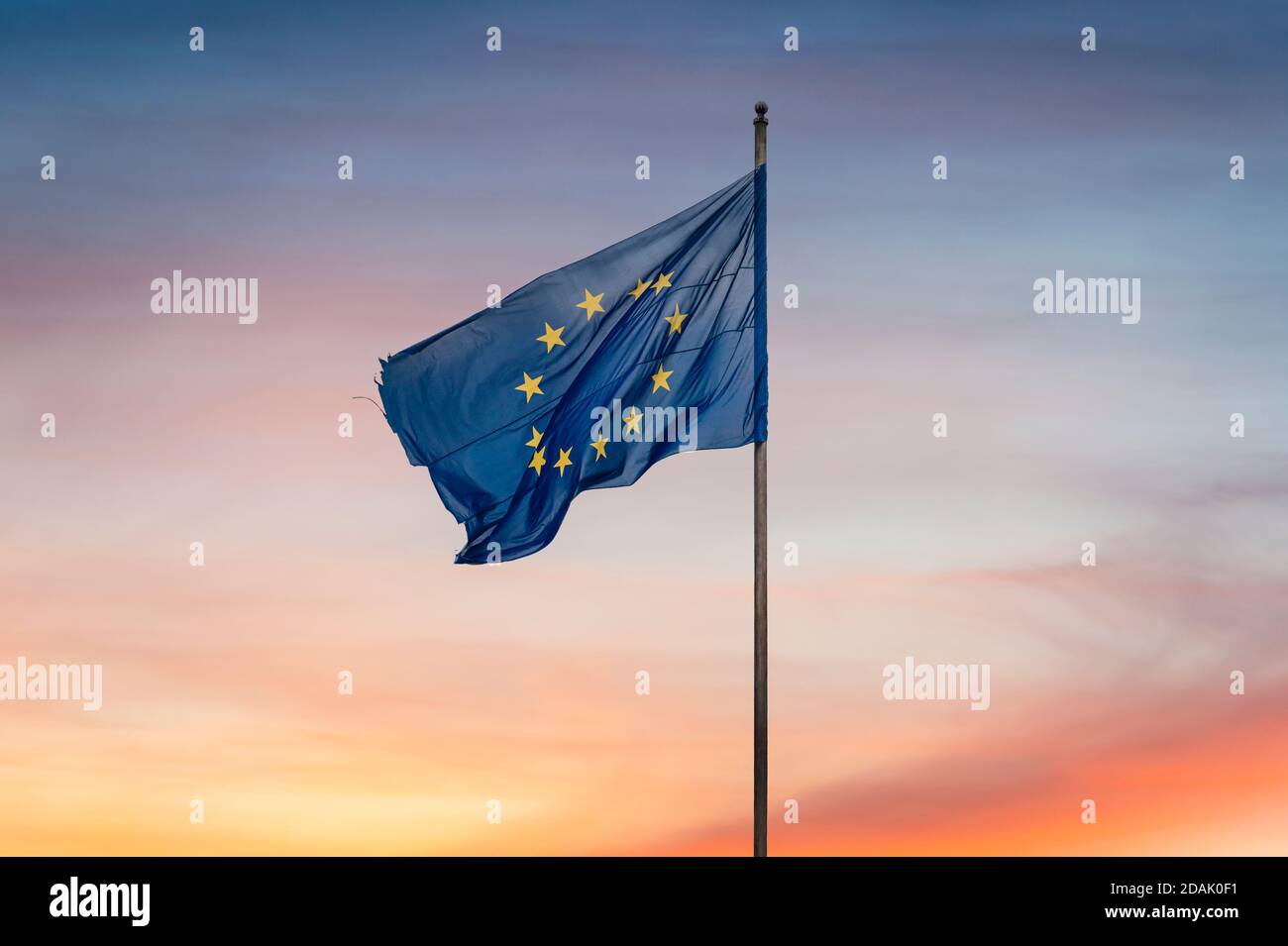 Zerfetzt / zerfetzt Europäische Union Flagge vor und Sonnenuntergang Hintergrund Die Europäische Union als Sonnenuntergangs bezeichnen - Konzept Stockfoto