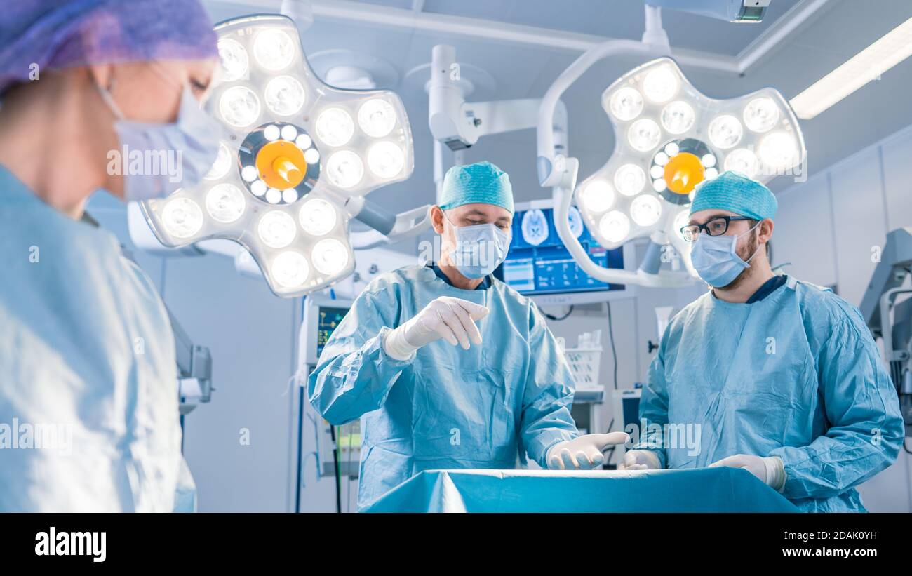 Vielfältiges Team von professionellen Chirurgen, Assistenten und Krankenschwestern, die invasive Chirurgie an einem Patienten im Operationssaal des Krankenhauses durchführen. Chirurgen Haben Stockfoto