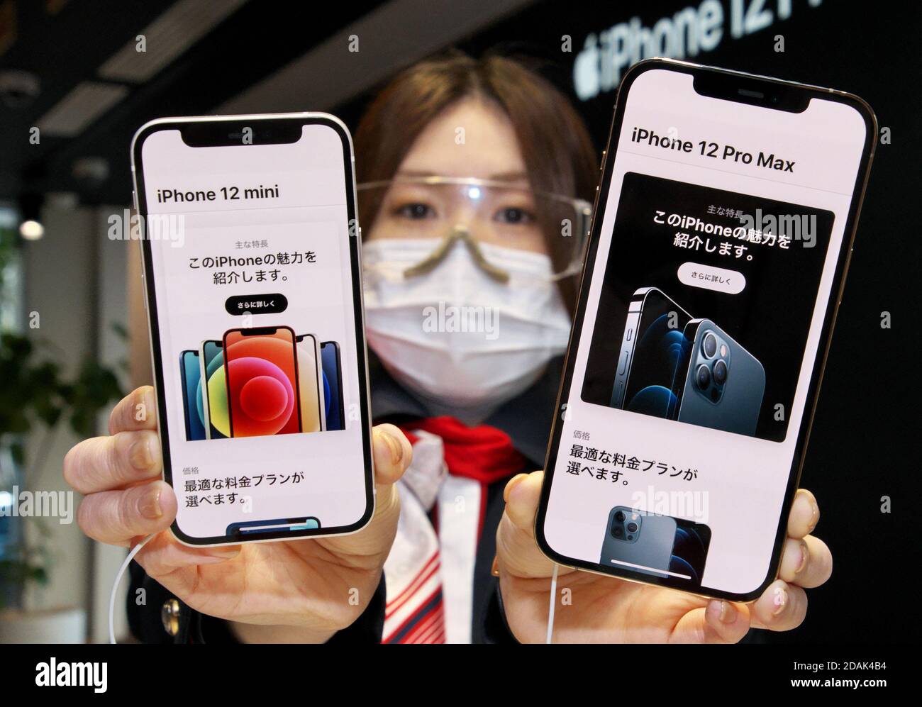 Ein Mitarbeiter posiert mit dem neuen iPhone 12 mini und 12 Pro Max während des Einführungstages im NTT docomo Marunouchi Store in Tokio, Japan am Freitag, 13. November 2020. Foto von Keizo Mori/UPI Stockfoto