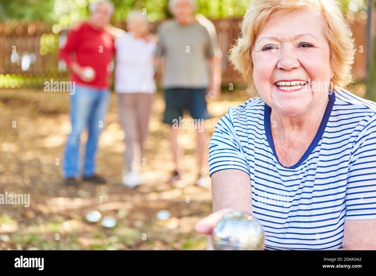 Glückliche ältere Frau mit Boule Ball ist glücklich über ein Erfolg im Wettbewerb Stockfoto