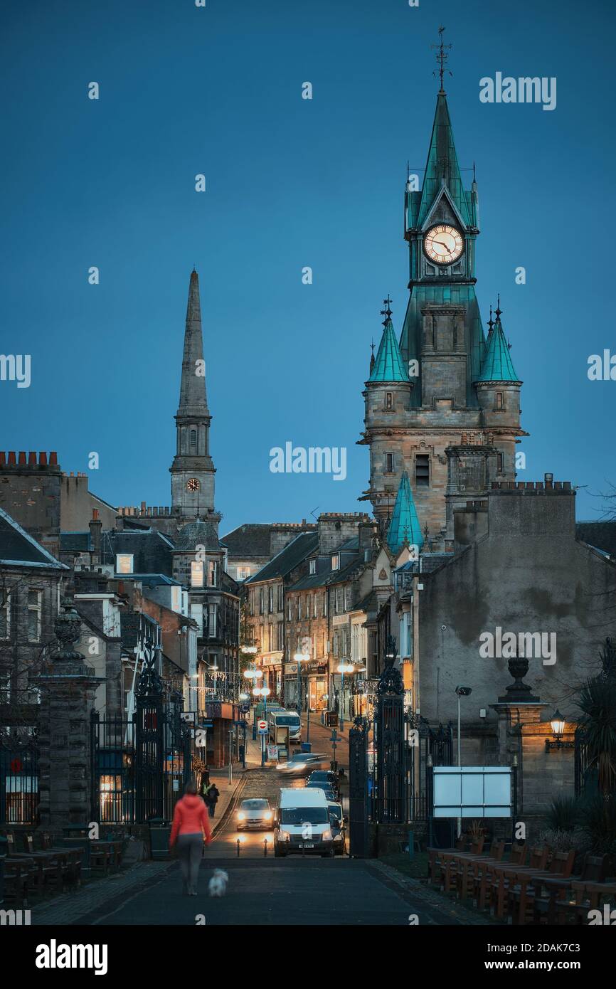 DUNFERMLINE, VEREINIGTES KÖNIGREICH - 04. NOVEMBER 2020: Eine Stadtstraße der alten historischen Stadt am Abend mit Spaziergänger und Straßenlaternen. Bridge Street, Dunfermline, Schottland Stockfoto