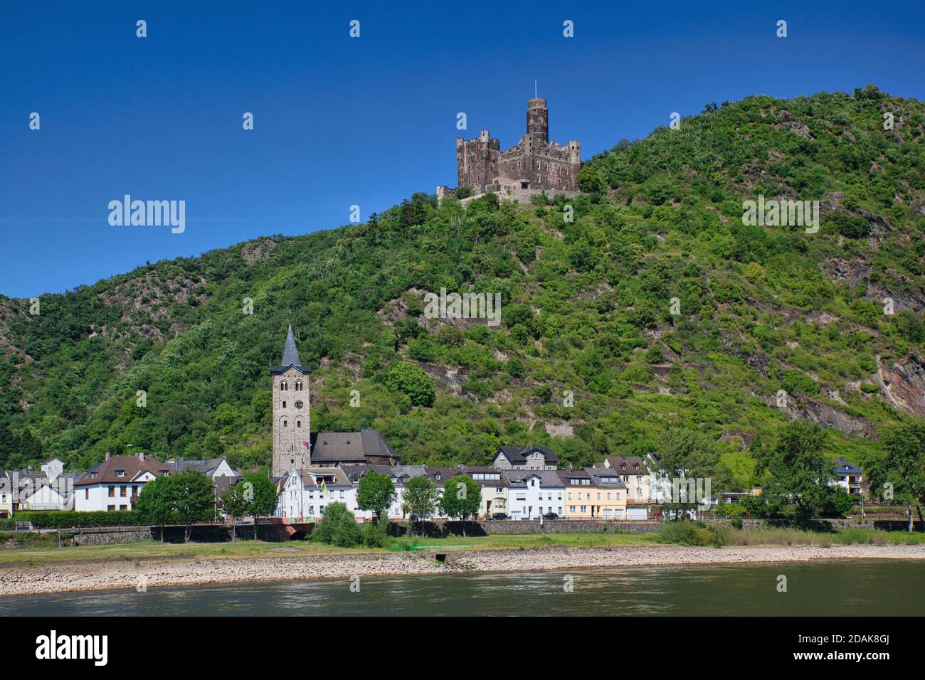 Eine Stadt am Rhein mit einem Schloss auf dem Hügel dahinter vor blauem Himmel. Der Rhein, Deutschland Stockfoto