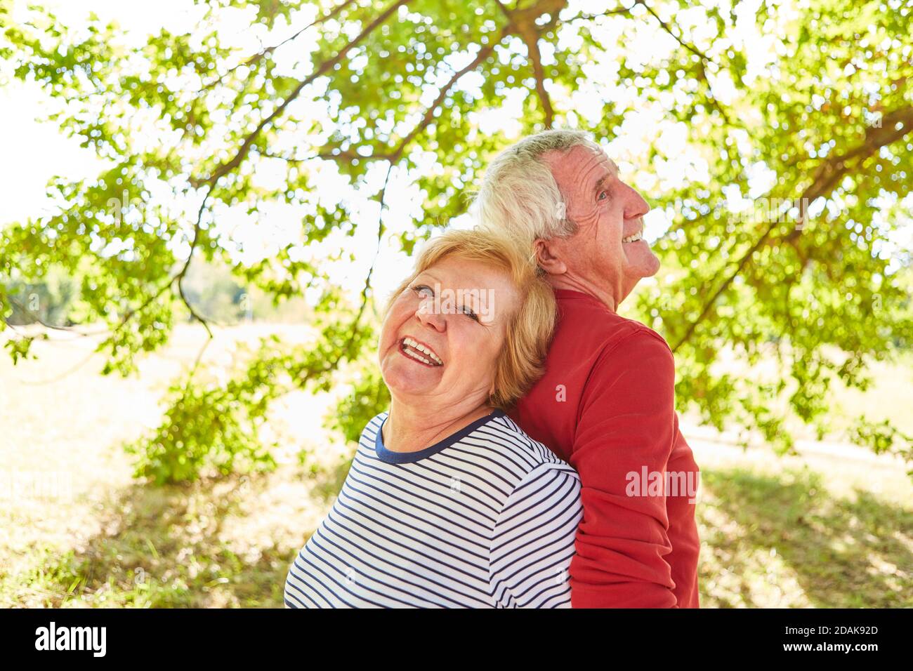 Glückliches Seniorenpaar in der Liebe stehen zurück zu zurück in Ein Park im Sommer Stockfoto