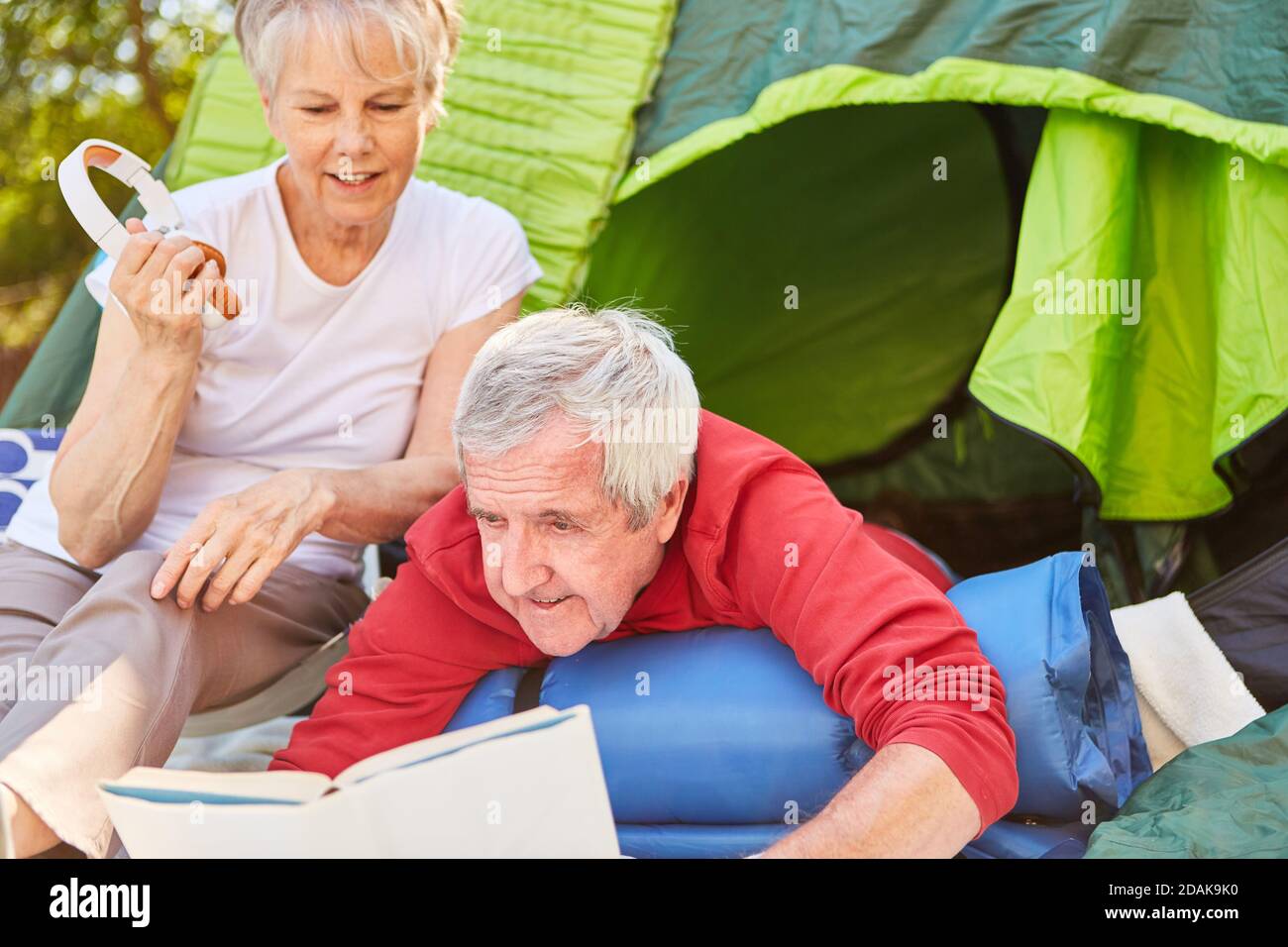 Seniorenpaar Beim Gemeinsamen Lesen Des Buches Vor Dem Zelt Camping Urlaub Im Freien Stockfoto