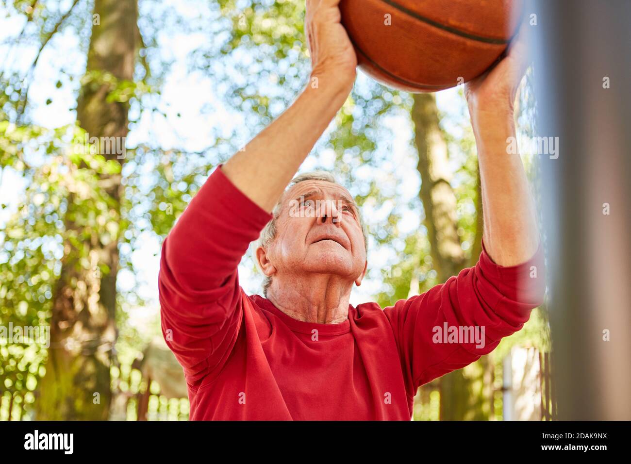 Sportlich und konzentriert Senior mit Ball beim Basketball spielen vor Der freie Wurf Stockfoto