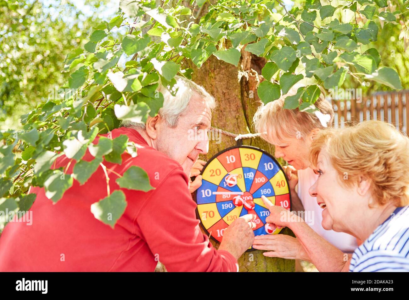 Gruppe von Senioren an der Dartscheibe, während die Punkte in zählen Der Garten im Sommer Stockfoto