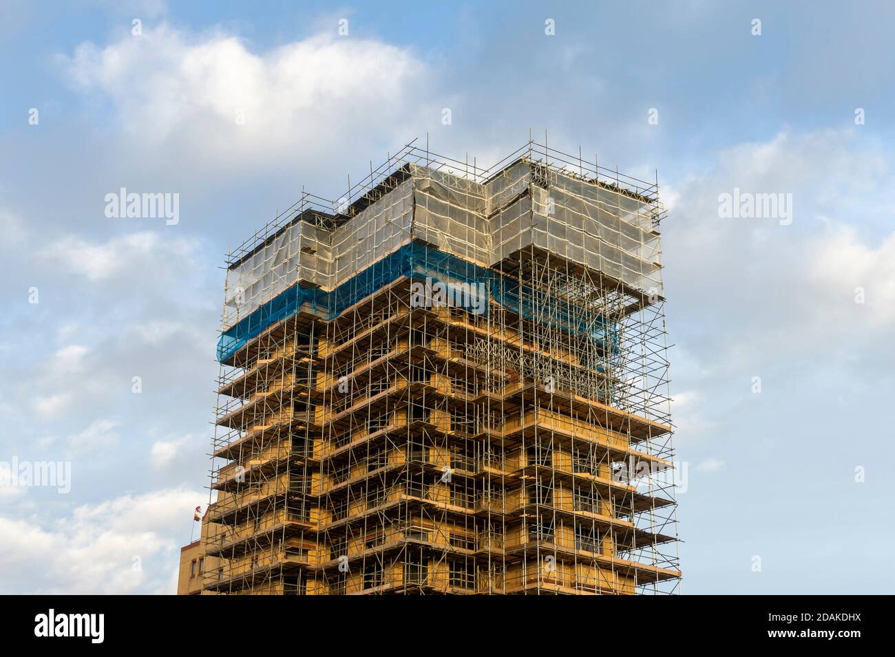 Gerüste auf einem Wohnblock, der in einem großen Gebäude renoviert wird Arbeiten Stockfoto