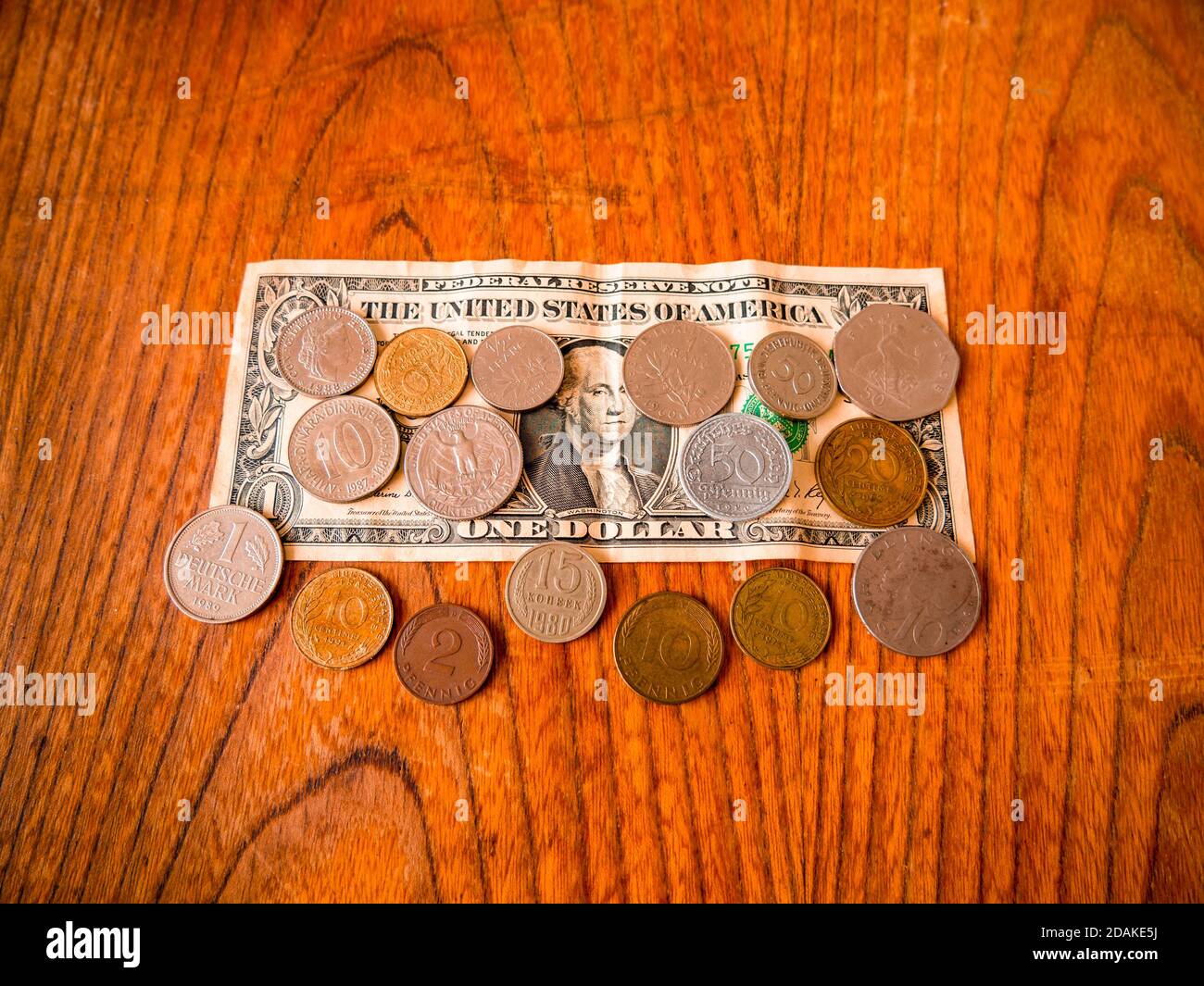 Eine US-Dollar-Banknote und Münzen verschiedener Länder Stockfoto