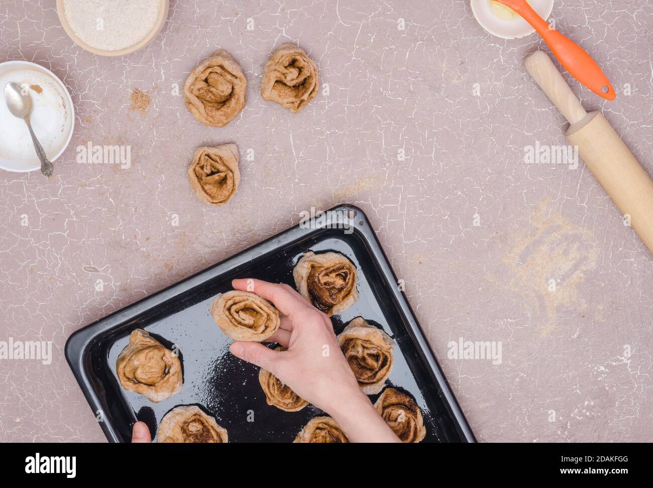 Ein Schritt-für-Schritt-Rezept für süße Zimtschnecken. Schritt 11 - Legen Sie die fertigen Rosen auf ein gefettetes Backblech Stockfoto