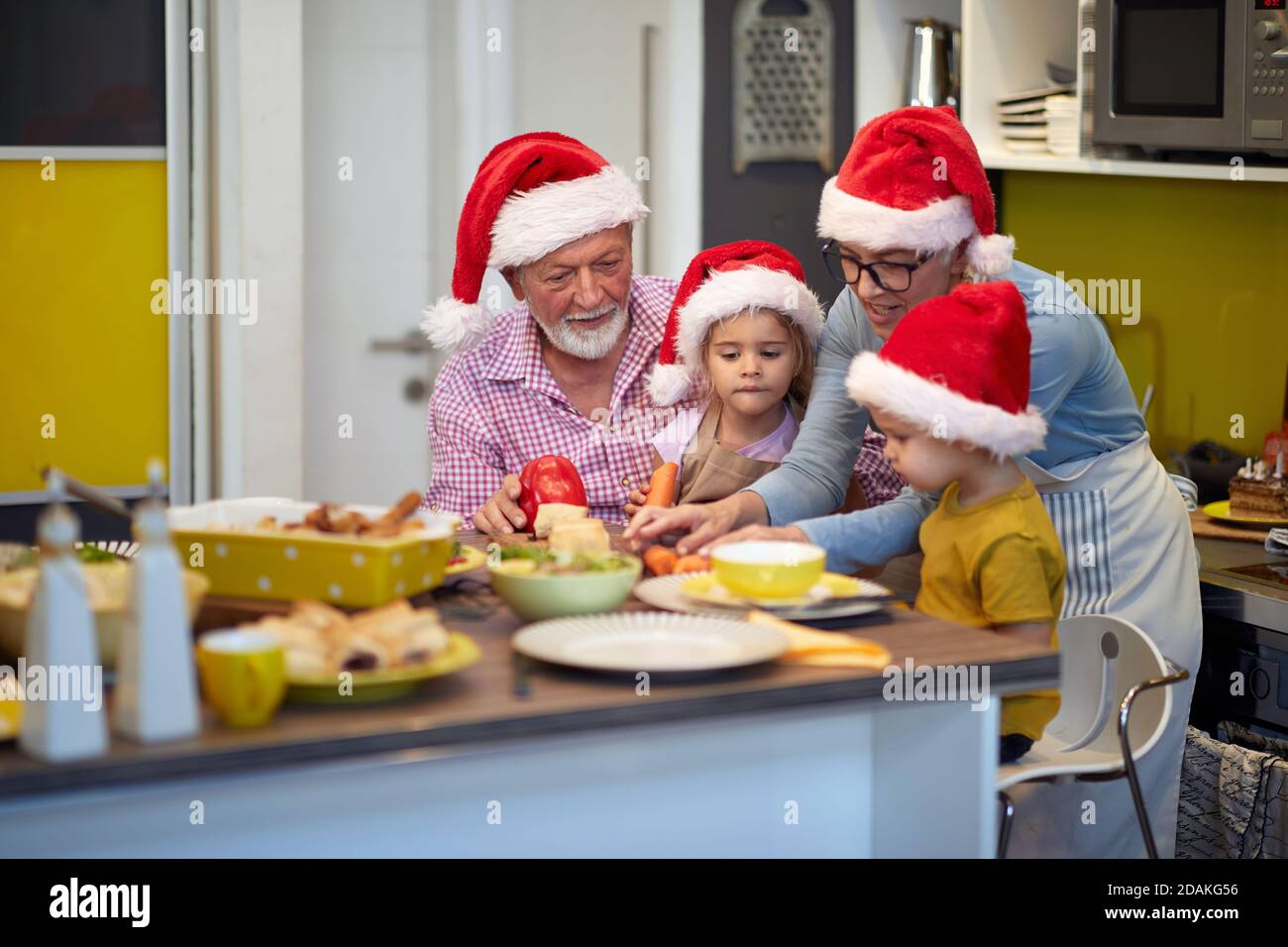 Großeltern und Enkelkinder verbringen gerne Zeit in der Küche zusammen bei Weihnachten Mahlzeit Vorbereitung in einer festlichen Atmosphäre. Weihnachten, Familie, zusammen Stockfoto