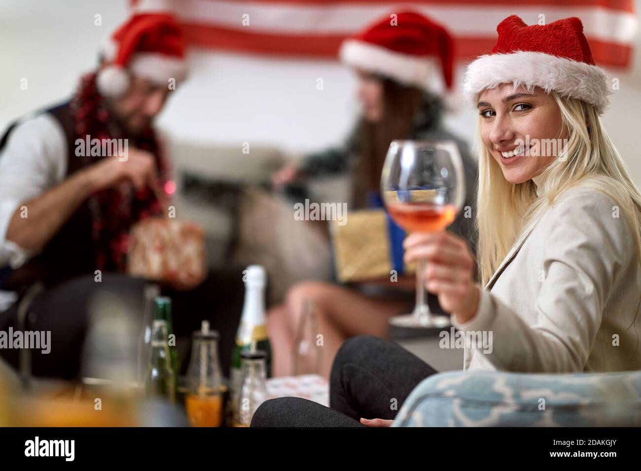 Porträt einer jungen glücklichen amerikanischen Frau feiert Weihnachten mit Freunde Stockfoto