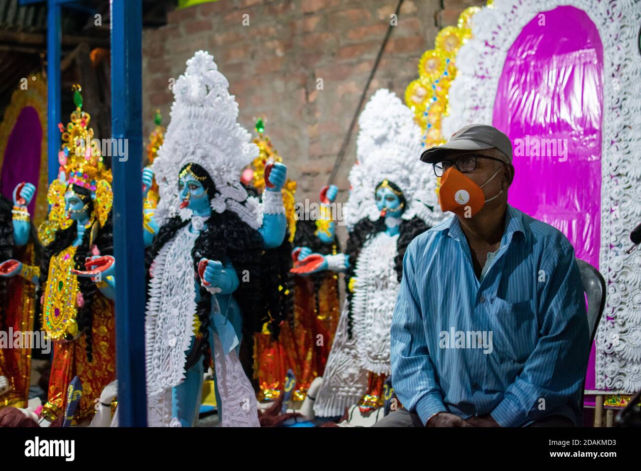 Barrackpore, Westbengalen, Indien. November 2020. Ein Mann, der gekommen ist, um ein Idol an den Ort des Festivals zu nehmen, wartet im Atelier des Künstlers, in dem die Idole der Göttin Kali gemacht werden. Die Regierung hat es erlaubt, wegen der Zunahme von COVID19-Fällen die Festivals von Kali Puja und Diwali unter strengen Pandemierichtlinien zu feiern. Aber die Frage bleibt, wie stark die Richtlinien von den einfachen Leuten befolgt werden. Quelle: Santarpan Roy/ZUMA Wire/Alamy Live News Stockfoto