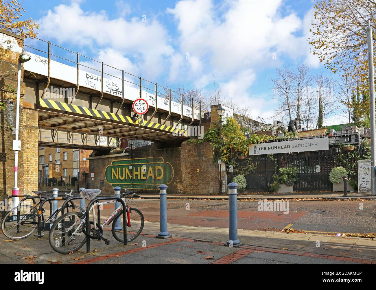 Nunhead Station, Southeast London, Großbritannien. Zeigt die Eisenbahnbrücke über die Gibbon Road neben dem Bahnhofseingang (Vordergrund). Stockfoto