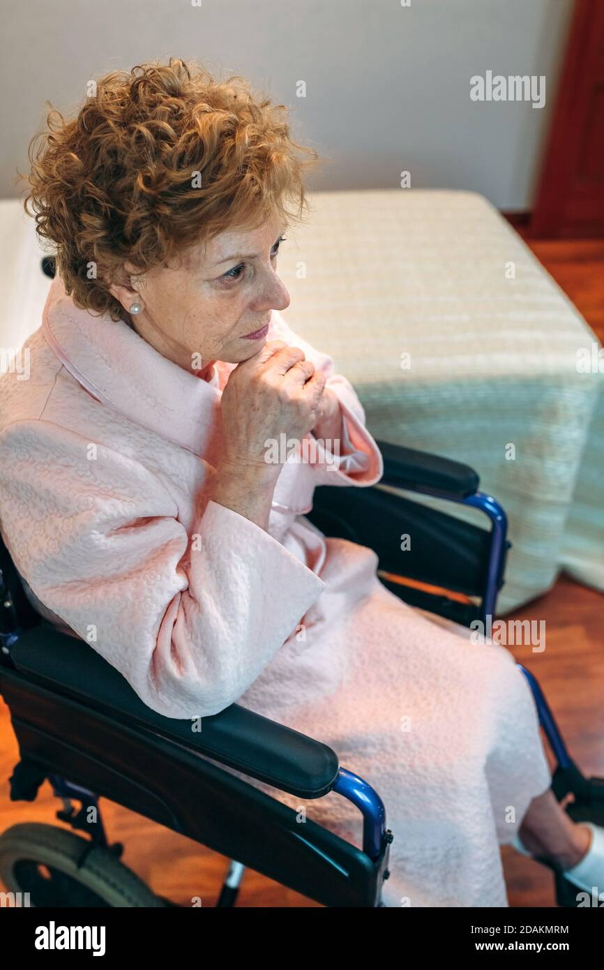 Ältere Frau im Rollstuhl allein Stockfoto