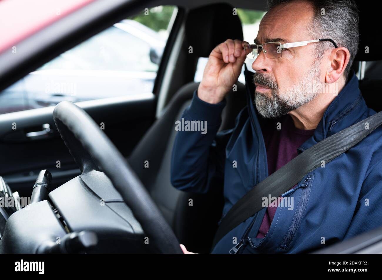 Älterer Männlicher Autofahrer Auf Dem Vordersitz Stockfoto