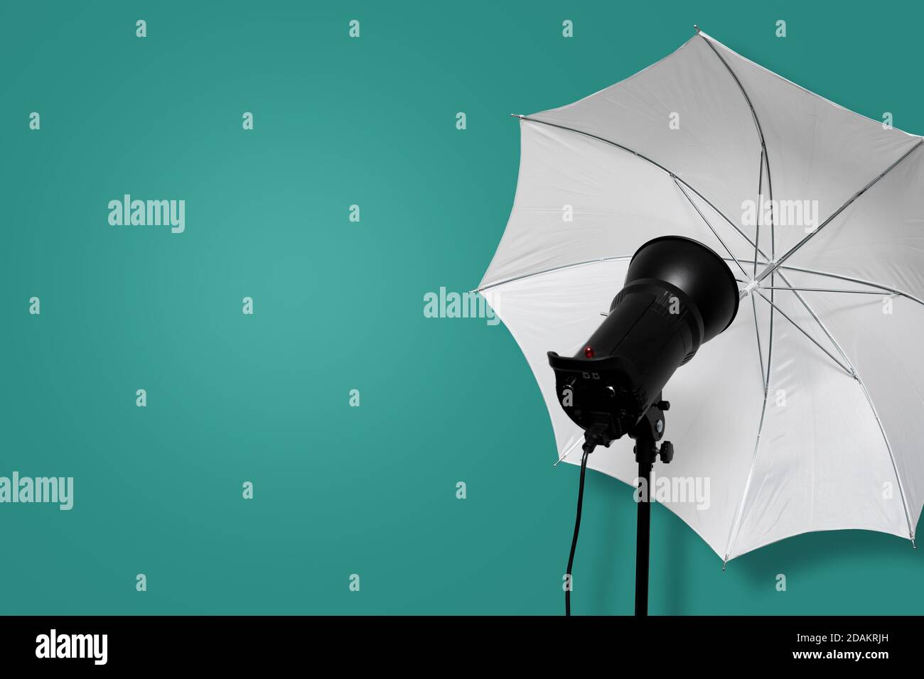 Foto Studio Blitz Strobe mit weißem Regenschirm auf Ständer auf cyanfarbenem Hintergrund. Beleuchtung Ausrüstung. Kopieren Raum Stockfoto