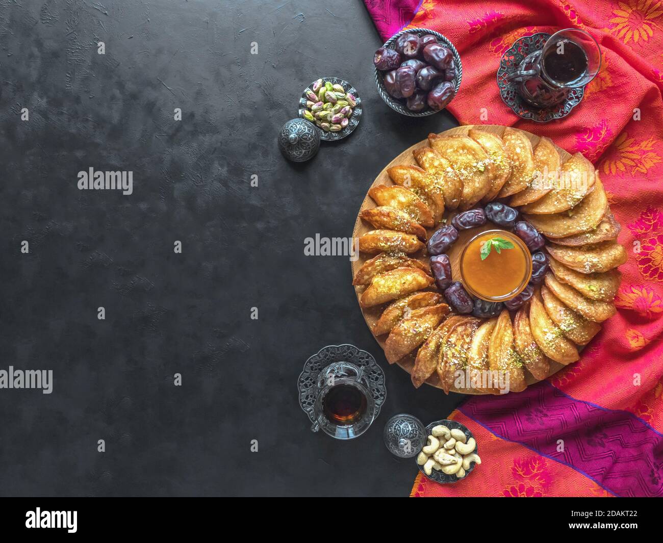 Arabische Süßigkeiten. Arabischer Pfannkuchen gefüllt mit süßem Käse und Pistazien. Festliche Ramadan Essen Hintergrund. Stockfoto