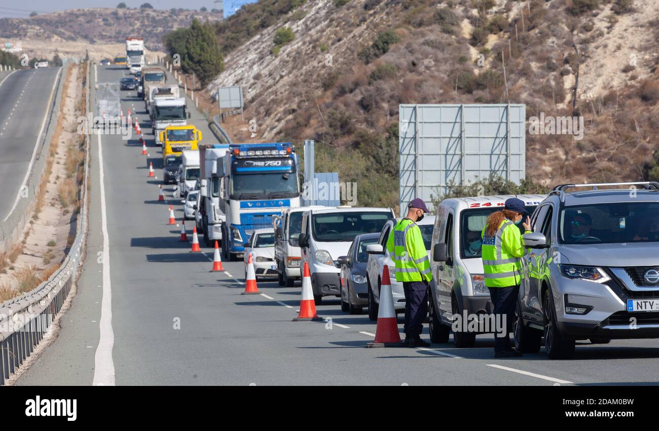 Limassol, Zypern. November 2020. Die Polizei trägt Masken überprüfen Fahrzeuge, bevor sie Limassol, Zypern, am 13. November 2020 betreten. Zypern verhängte neue strengere Maßnahmen zur Eindämmung des Coronavirus, einschließlich einer teilweisen lokalen Sperre in Limassol und Paphos, nach einer Welle neuer Fälle, kündigte Präsident Nicos Anastasiades am Mittwoch an. Quelle: George Christophorou/Xinhua/Alamy Live News Stockfoto