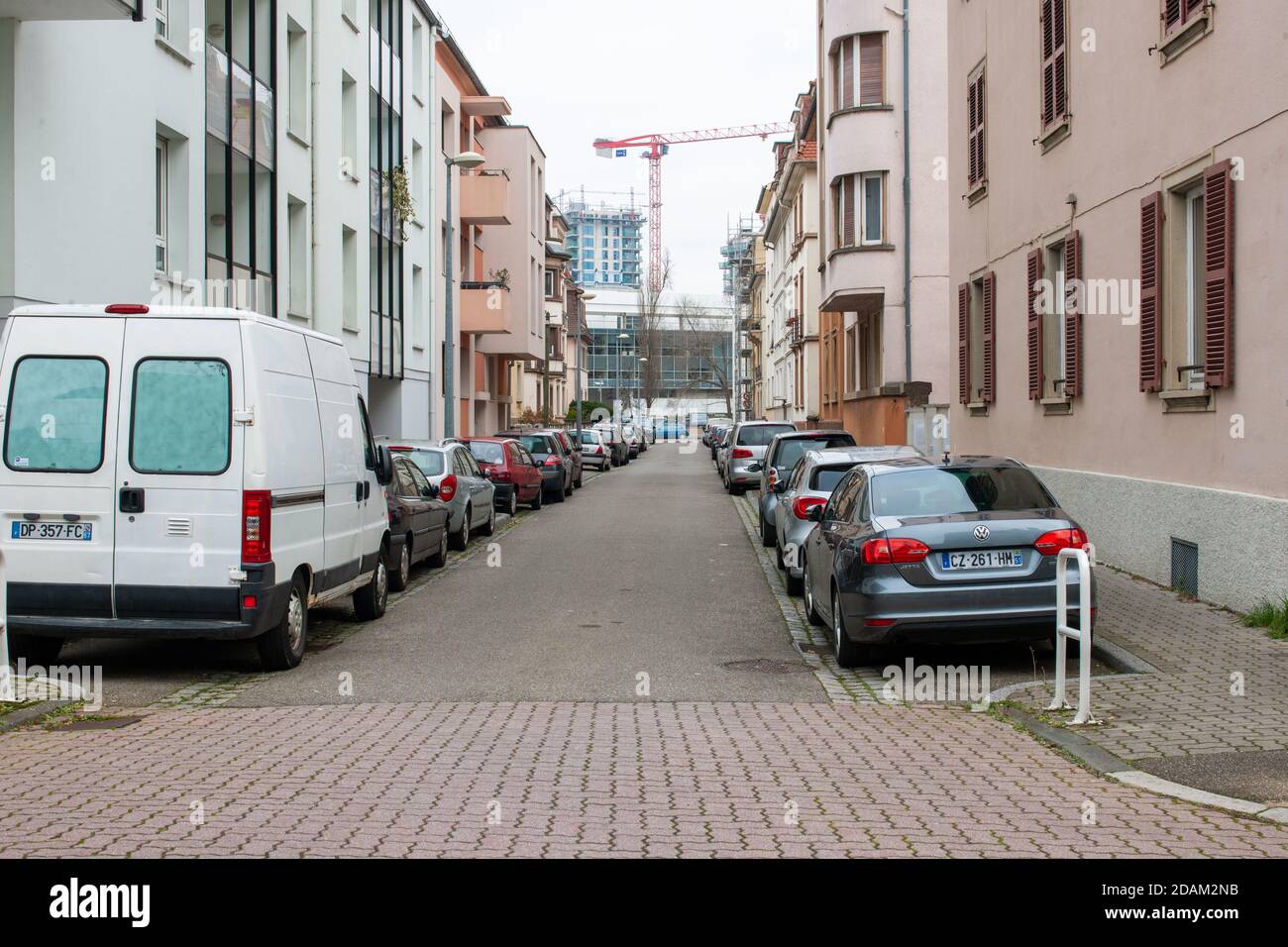 Straßburg, Frankreich - 2. Dezember 2016: Leere Straße in Straßburg mit Reihen von geparkten Autos und Baustelle in Perspektive Stockfoto