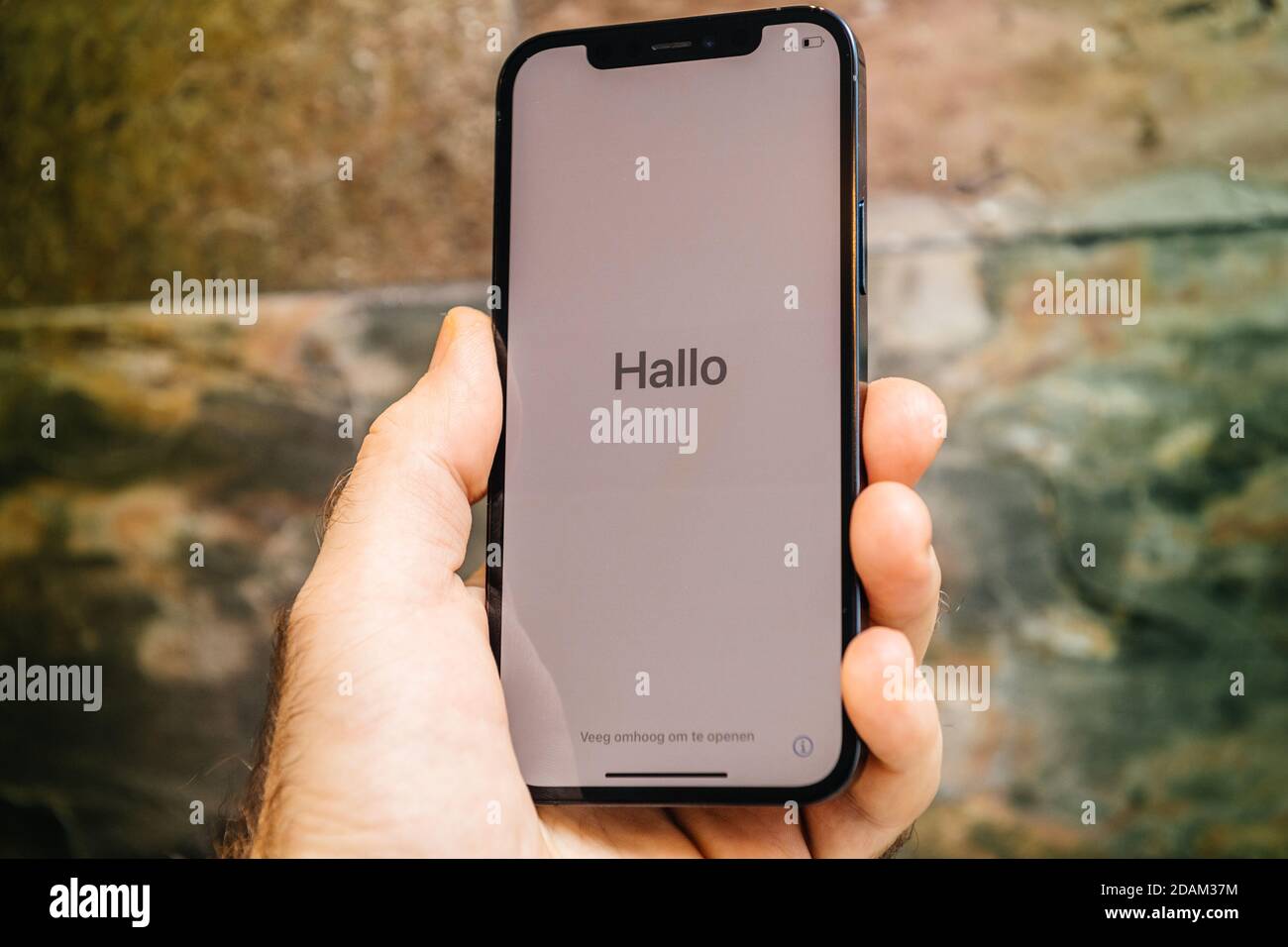 Paris, Frankreich - 11. Nov 2020: Hallo deutsch Hallo Wort in als Mann Hand hält neue iPhone 12 Pro Max 5G Smartphone-Modell von Apple Computers Nahaufnahme von Pacific Blue Handy-Gerät während der ersten Einrichtung iOS-Aktivierung Stockfoto