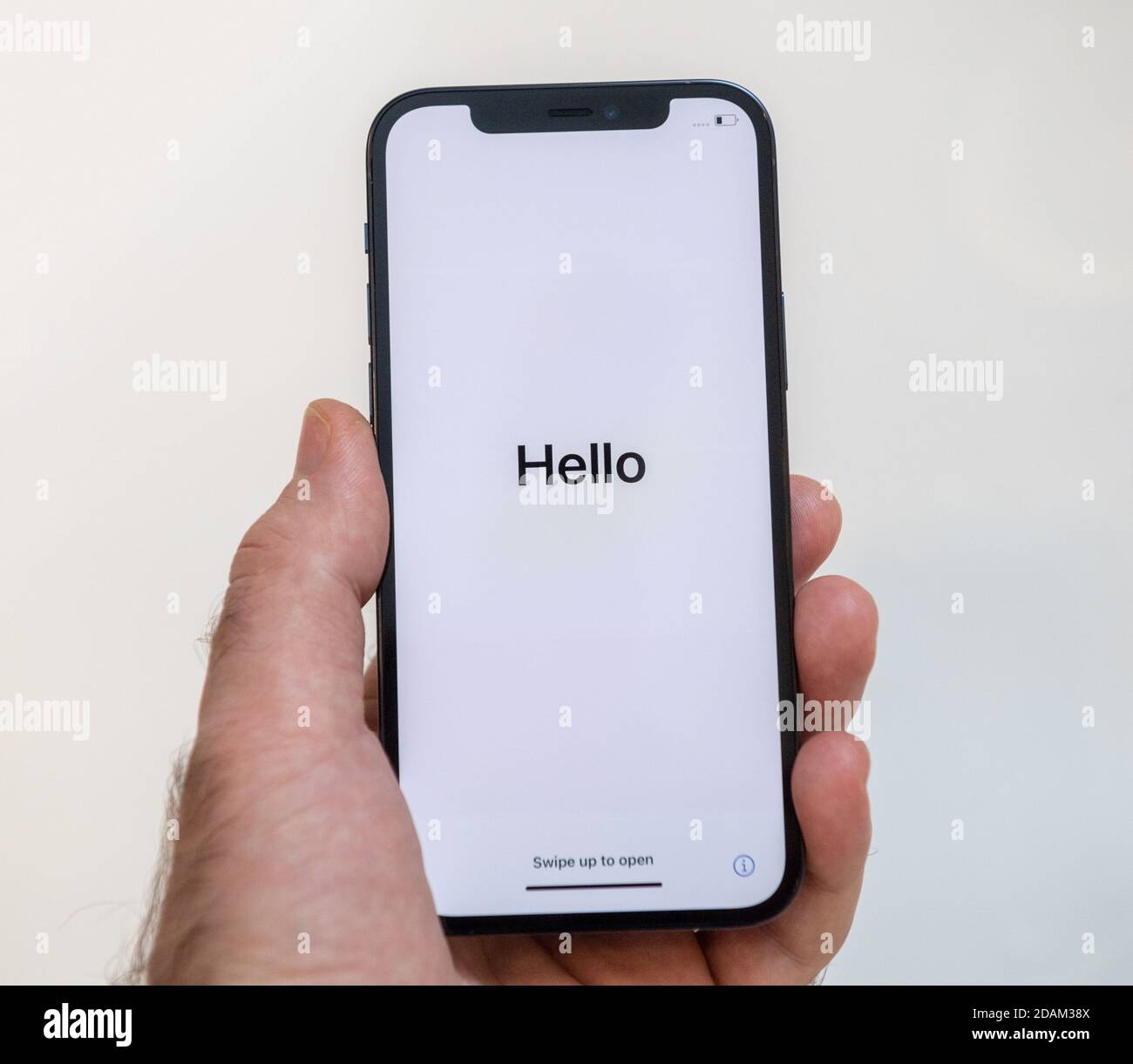 Paris, Frankreich - Nov 11, 2020: Hallo Wort in als Mann Hand hält neue iPhone 12 Pro Max 5G Smartphone-Modell von Apple Computers Nahaufnahme von Pacific Blue Handy-Gerät während der ersten Einrichtung iOS-Aktivierung Stockfoto