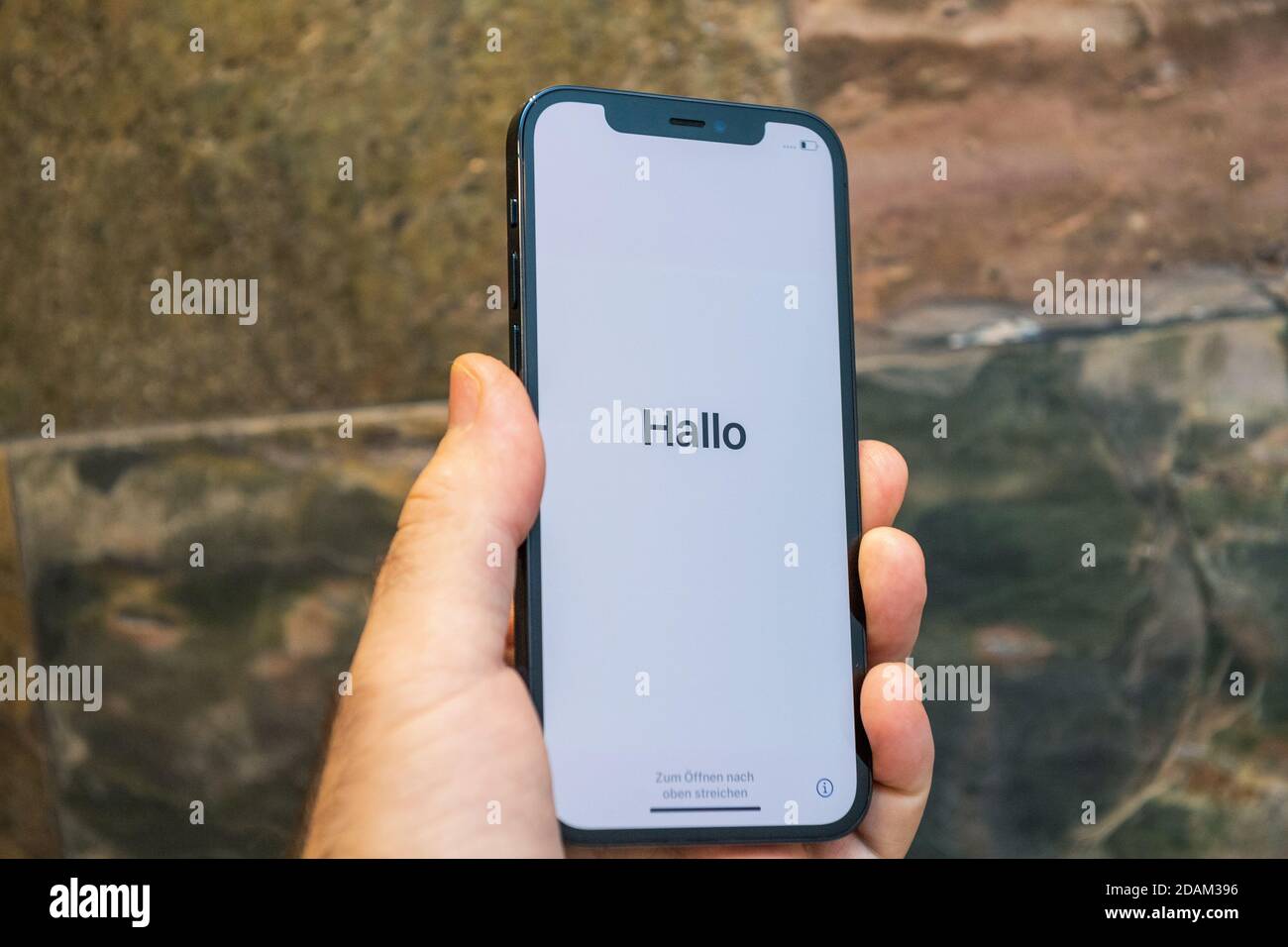 Paris, Frankreich - 11. Nov 2020: Hallo deutsch Hallo Wort in als Mann Hand  hält neue iPhone 12 Pro Max 5G Smartphone-Modell von Apple Computers  Nahaufnahme von Pacific Blue Handy-Gerät während der