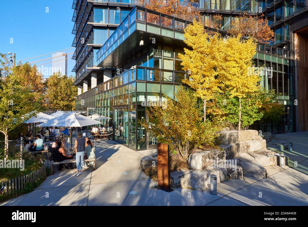 An einem sonnigen Herbsttag sitzen Gruppen an Tischen im Osprey Restaurant im Brooklyn Bridge Park. Stockfoto