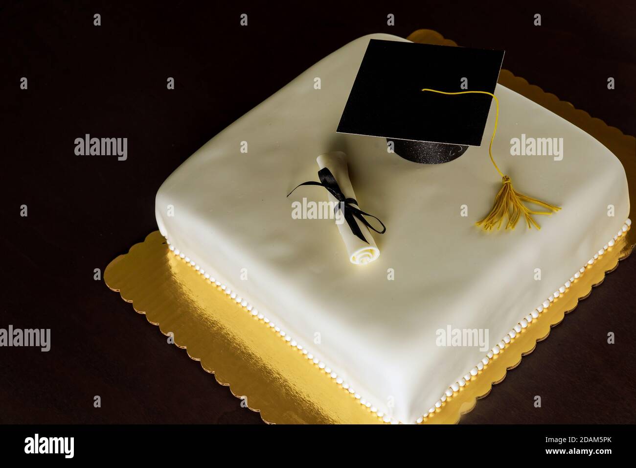 Graduierung weiße Kuchen mit Kappe auf der Oberseite und Diplom-Dekor. Stockfoto
