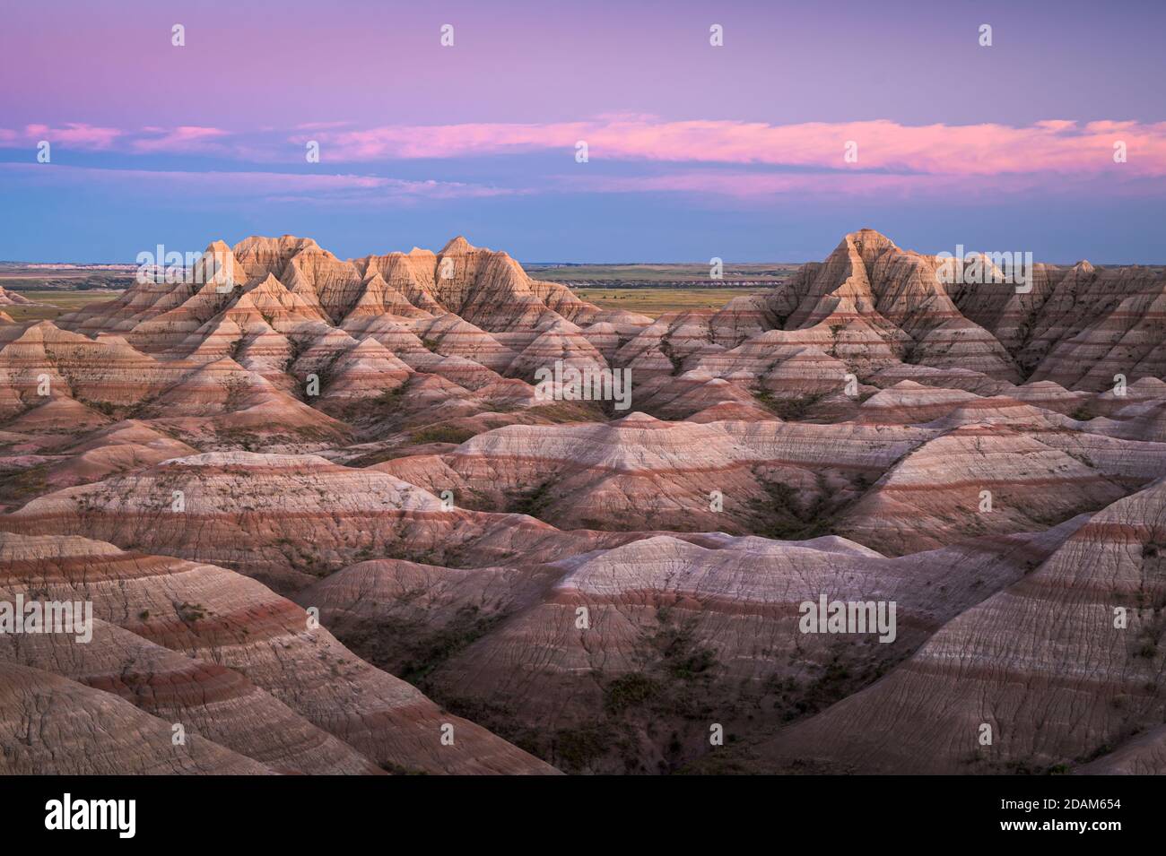 Dämmerung über den gestreift Zinnen und Schluchten des Badlands National Park in South Dakota, USA. Stockfoto