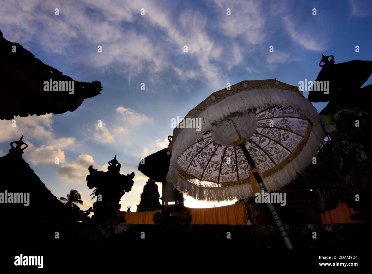 Silhouetten von Tempelgebäuden und hinterleuchtete Sonnenschirme an einem Tempel, während des Galungan Festivals. Ubud, Bali, Indonesien Stockfoto