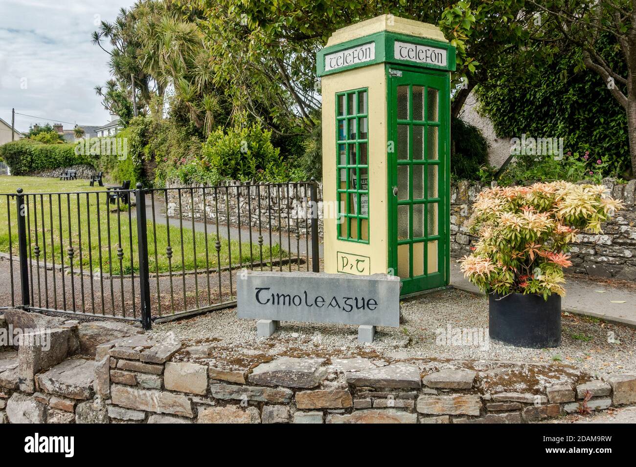 Telefonkasten im alten Stil und Timoleague-Schild in Timoleague, West Cork, Irland. Stockfoto