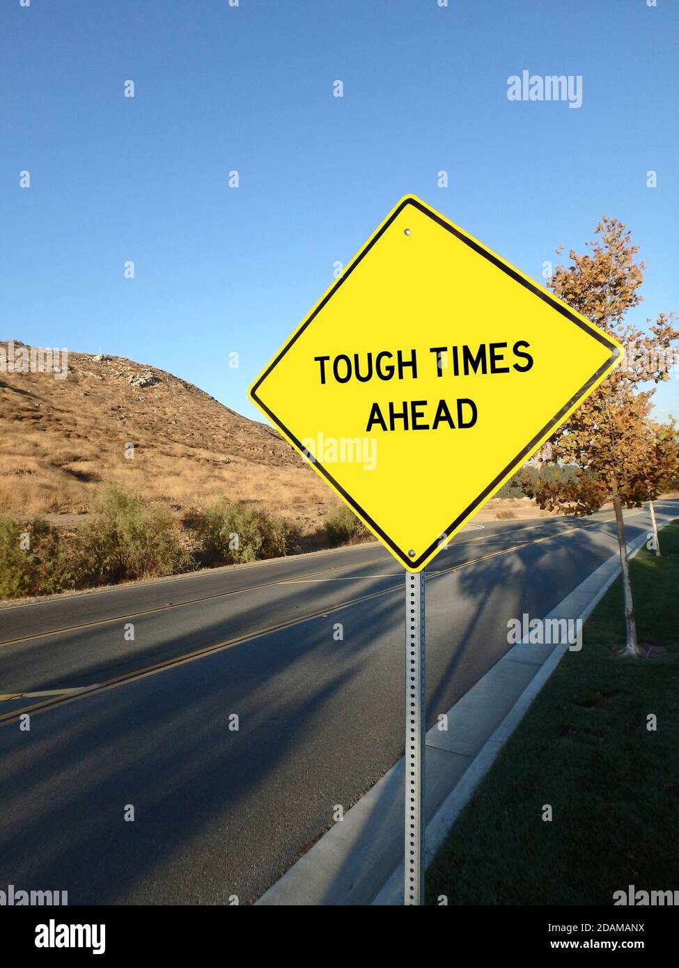 Gelbes Diamant-Straßenschild mit Ankündigung von Tought Times Ahead Stockfoto