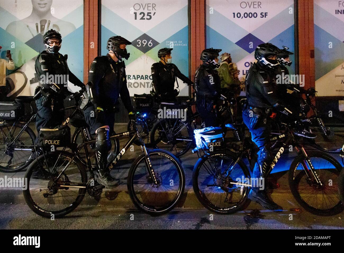 Stark orientierte NYPD-Offiziere auf Fahrrädern in der Nacht, vor der Wahl, Greenwich Village, New York City, New York, USA Stockfoto